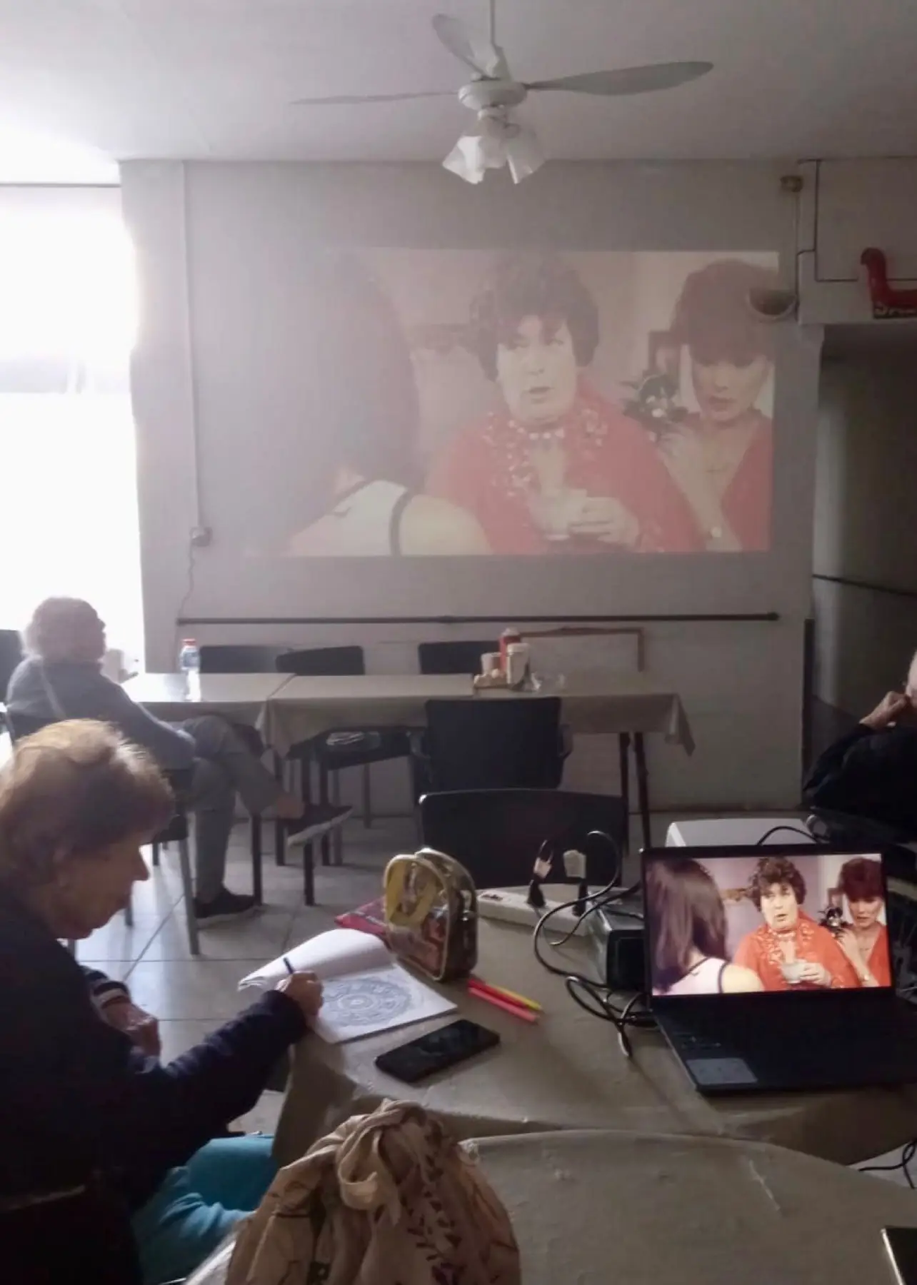Taller de cine: proyección de una película sobre la pared mientras una residente dibuja