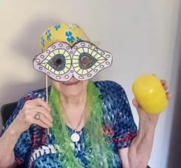 Residente mostrando la máscara de carnaval que pintó en el taller